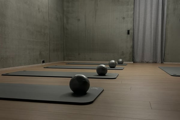 The calm mat studio with concrete walls and warm wooden floors